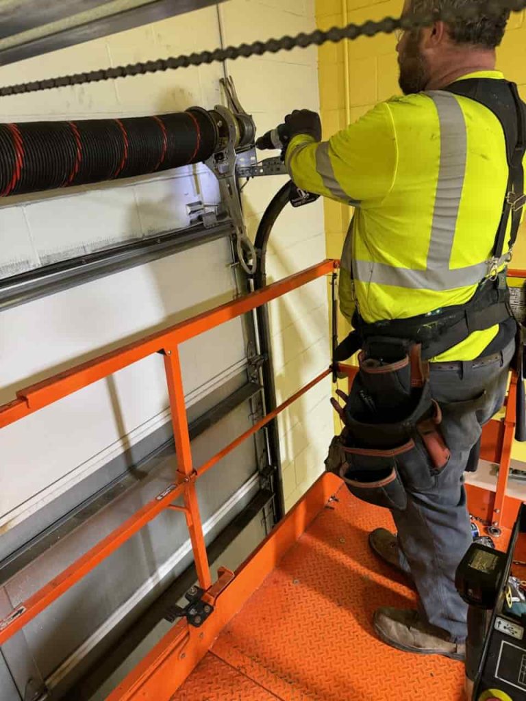 Contractor drilling into a garage door